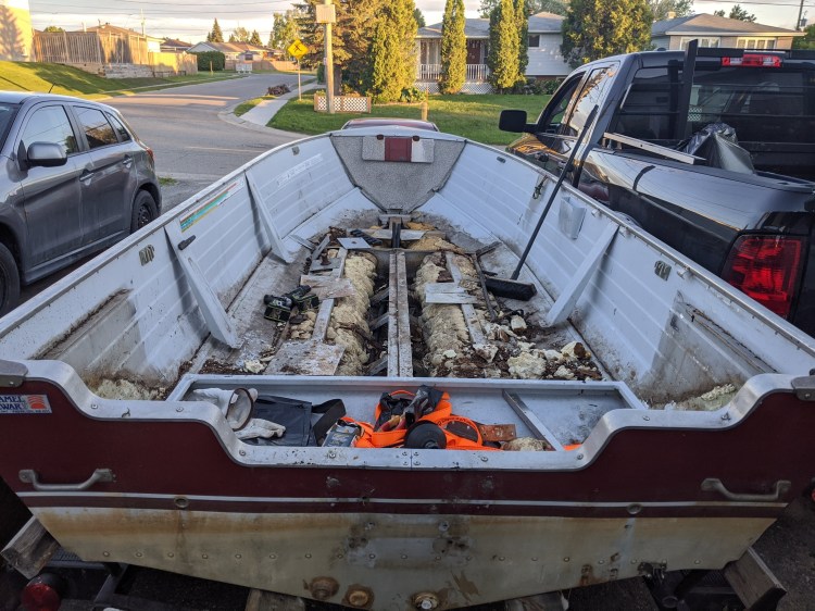 Picture of the inside of an aluminum boat that is messy and needs repair